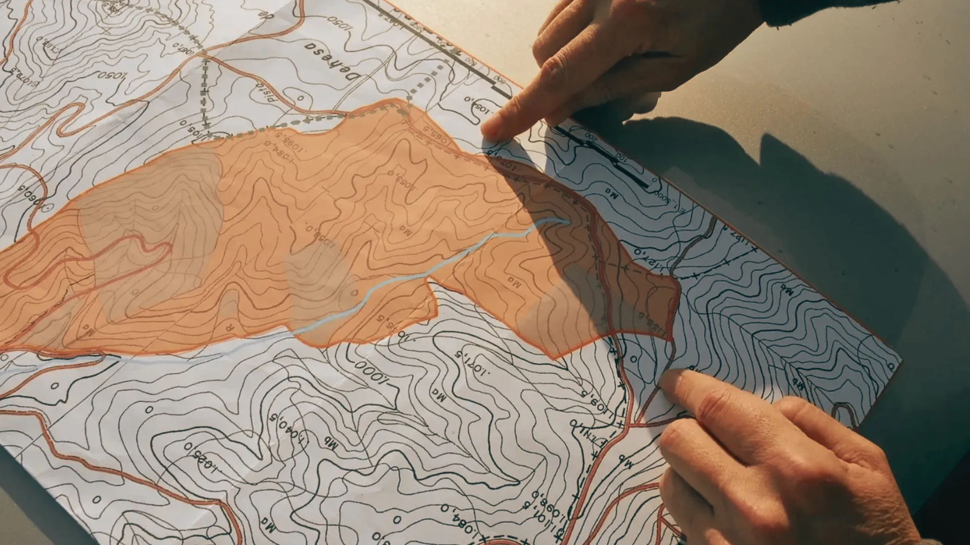 Manos sobre un mapa topogr&aacute;fico